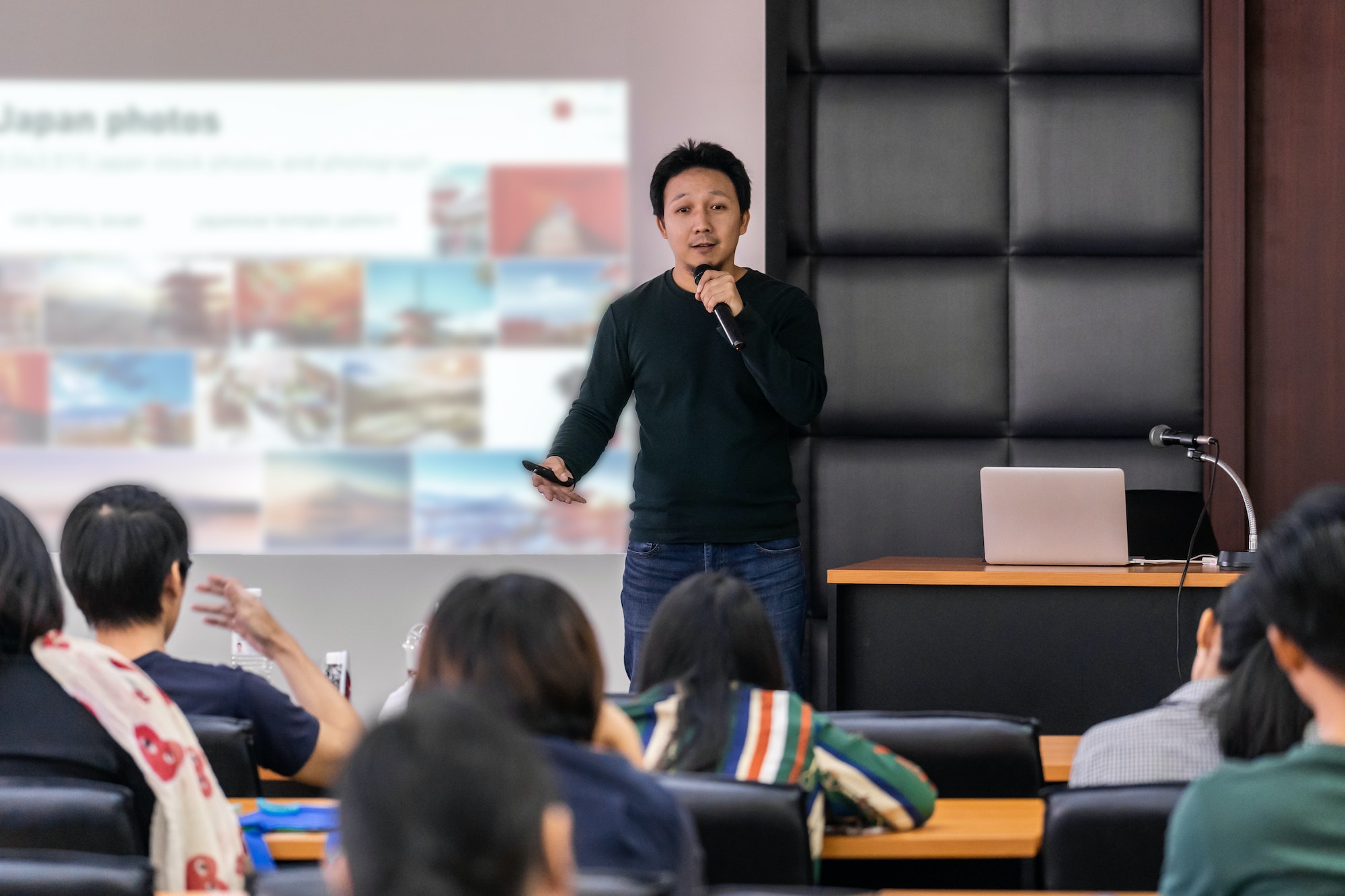 asian-speaker-or-lecture-with-casual-suit-on-the-stage-presenting-via-projector-screen.jpg